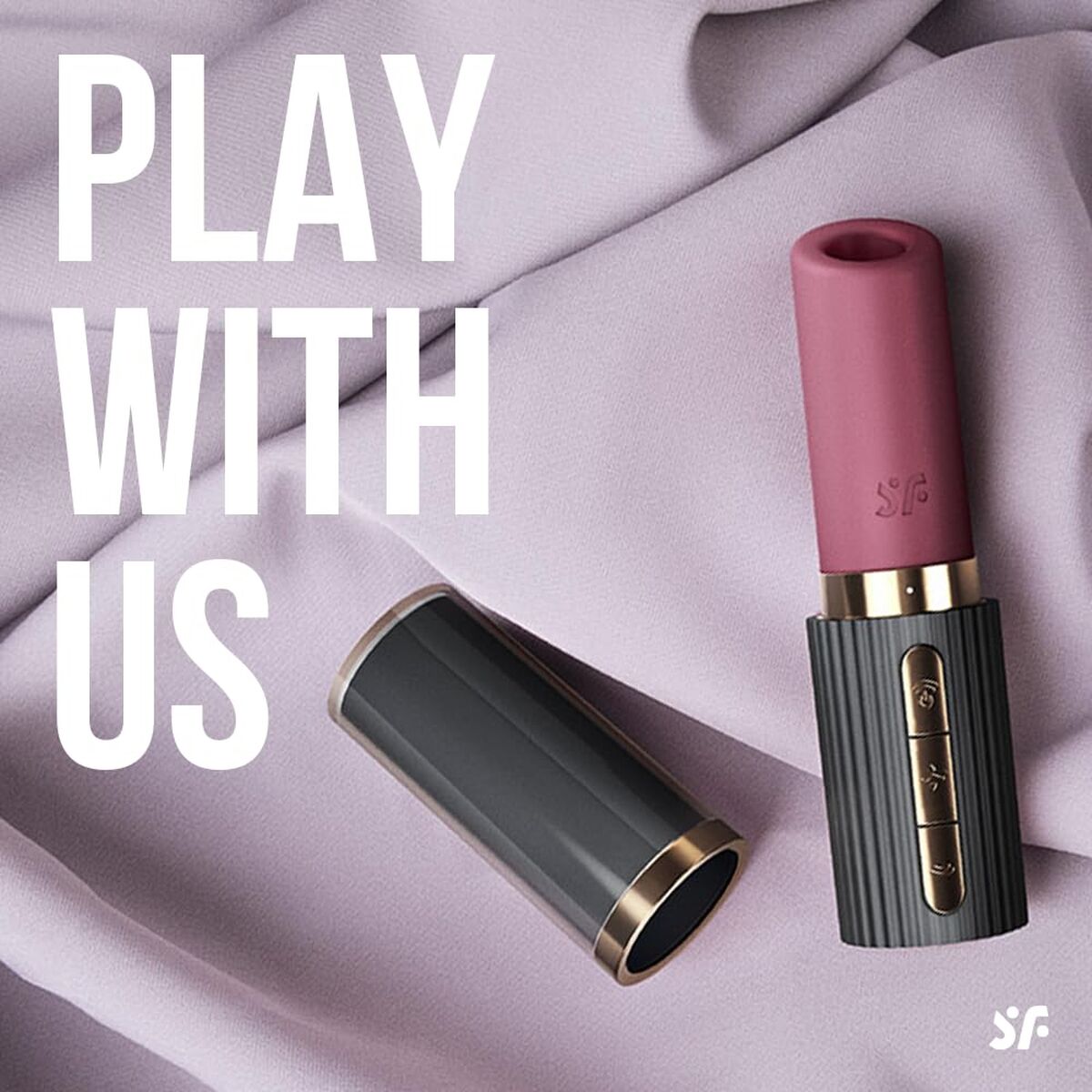 Pink lipstick vibrator with gold accents on a light purple fabric background, featuring the text 'Play With Us' and a logo.