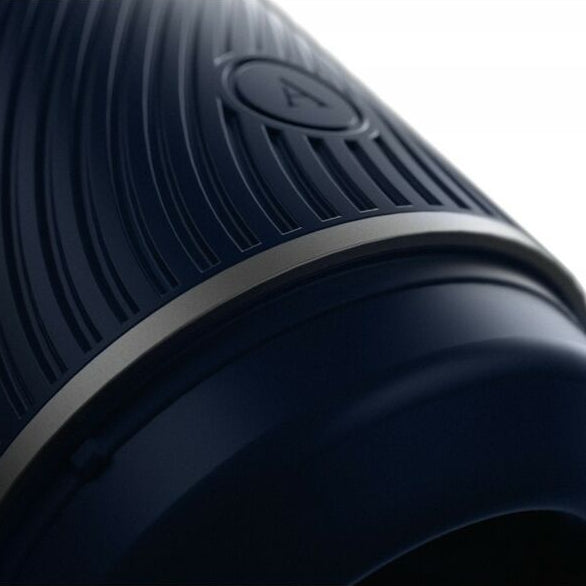 Close-up of a navy blue masturbator with a textured surface and a circular feature on a white background