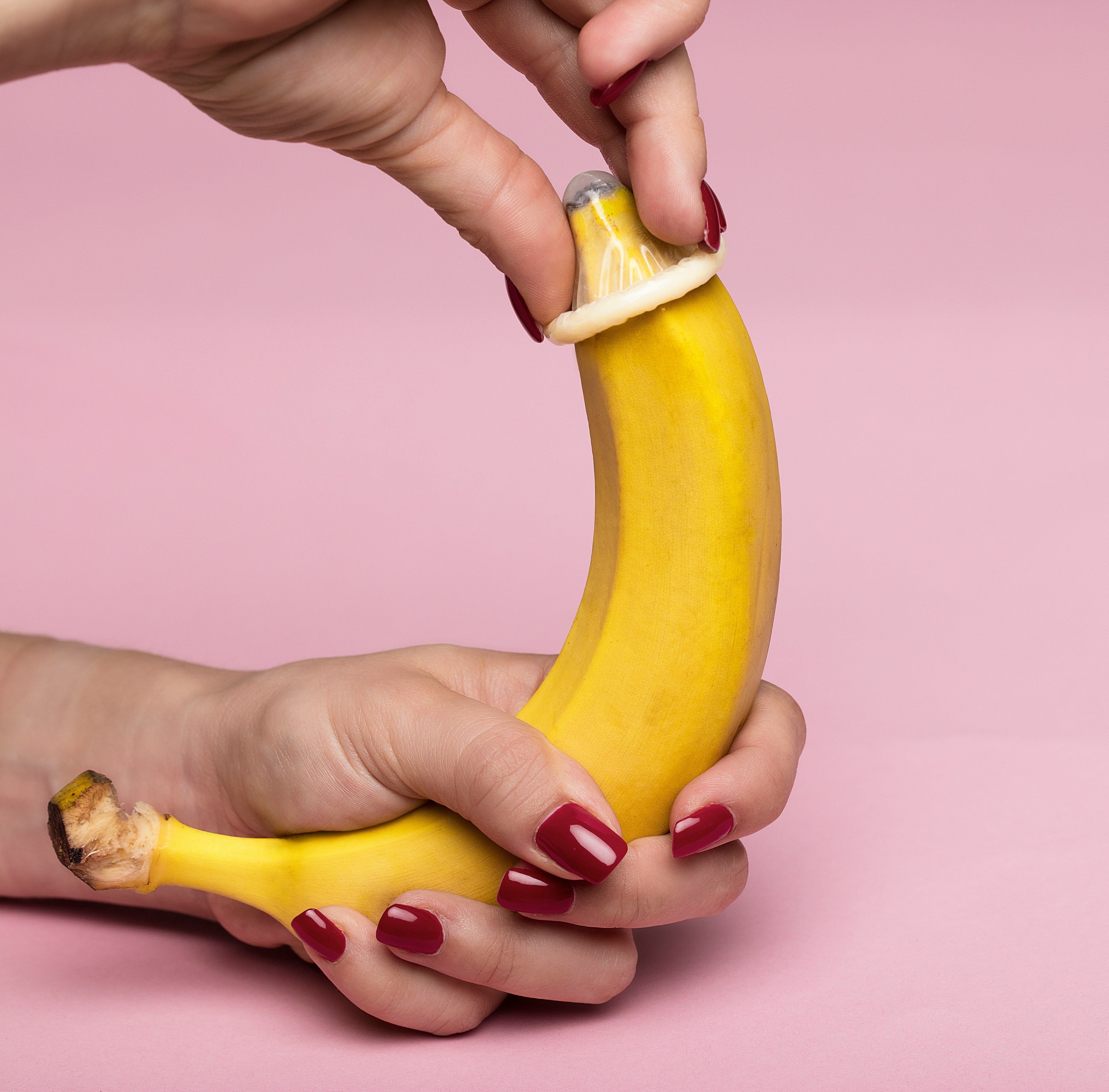 woman pulling condom on banana, bought in adult webshop