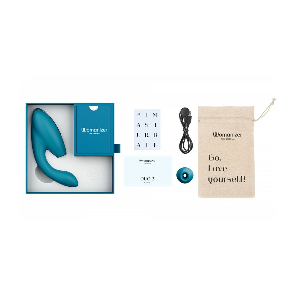 Womanizer erotic adult product set with packaging, manual, and charging cable on a white background