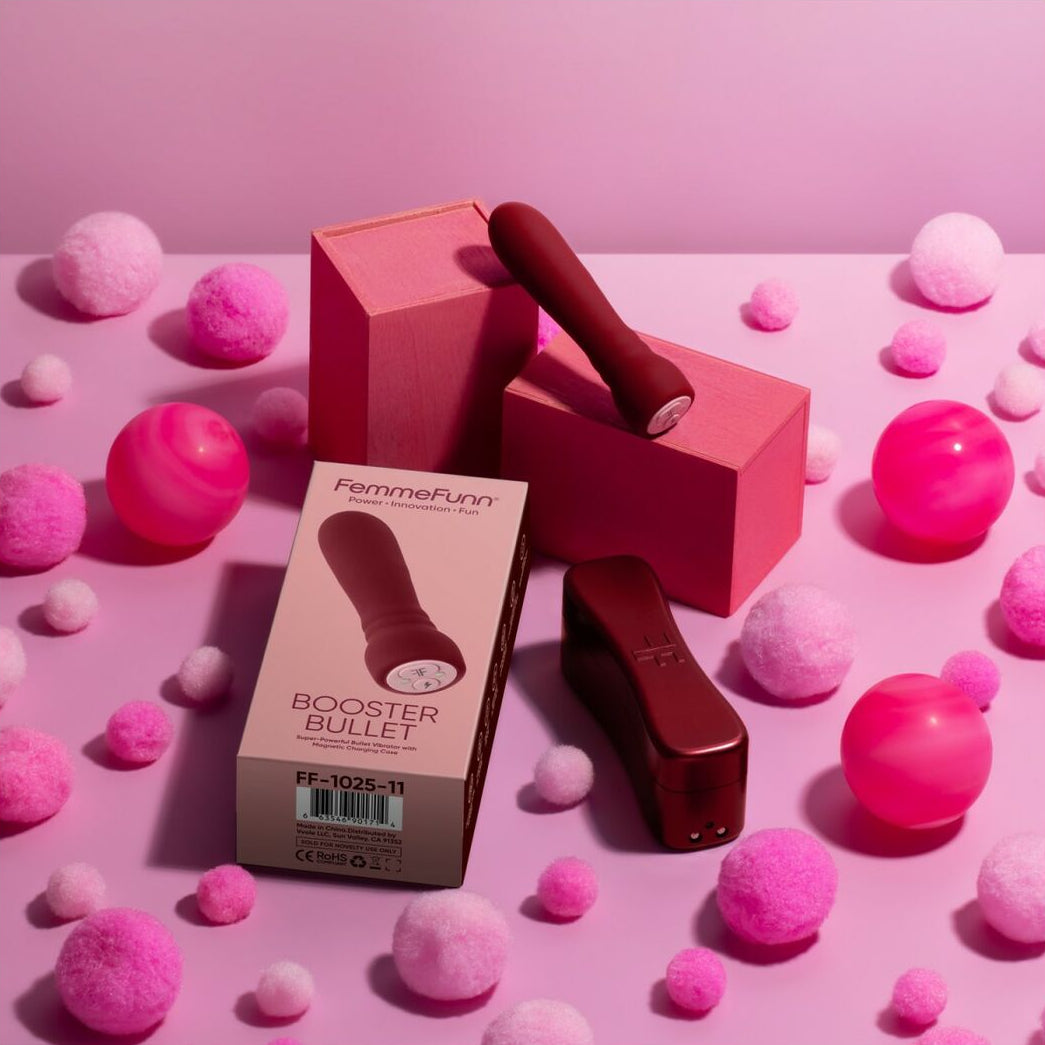 Red booster bullet vibrator with packaging on a pink background with pink balls