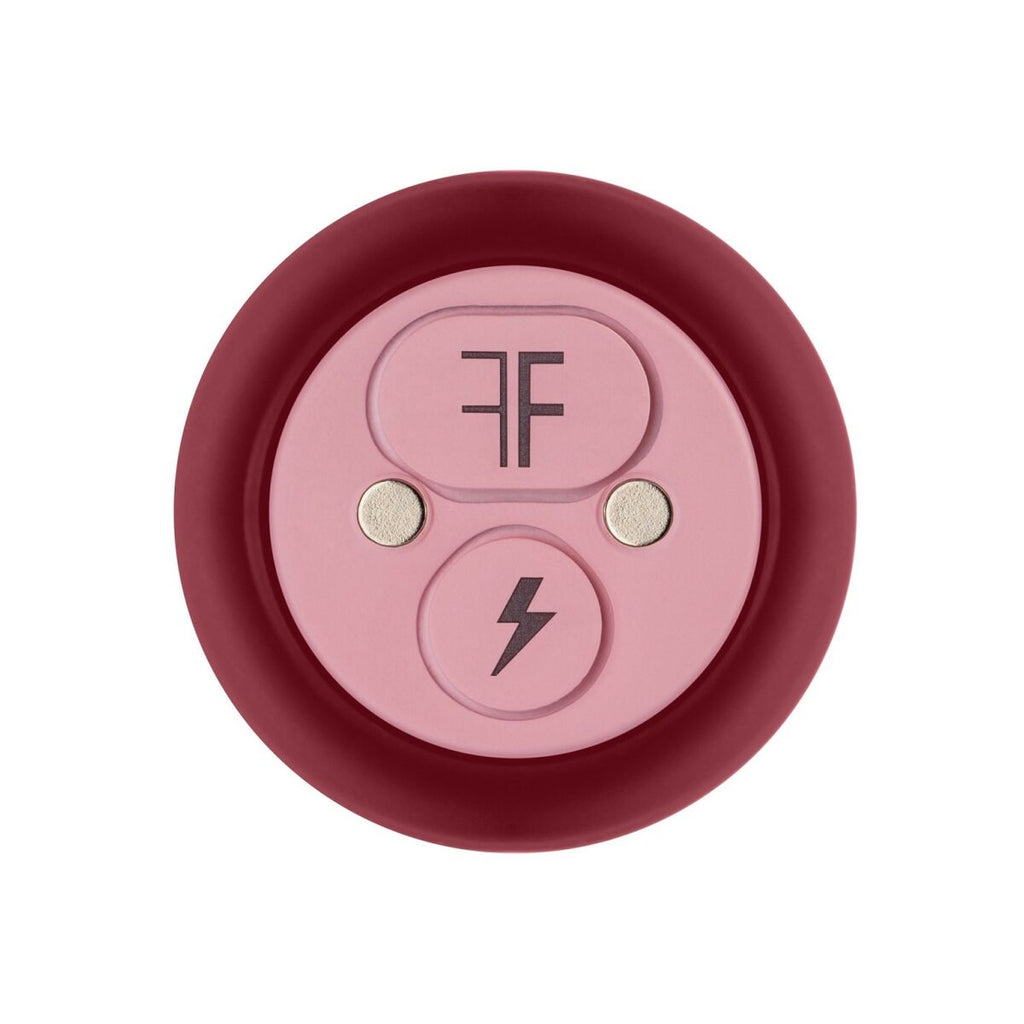 Round device with pink center buttons and red border on a white background