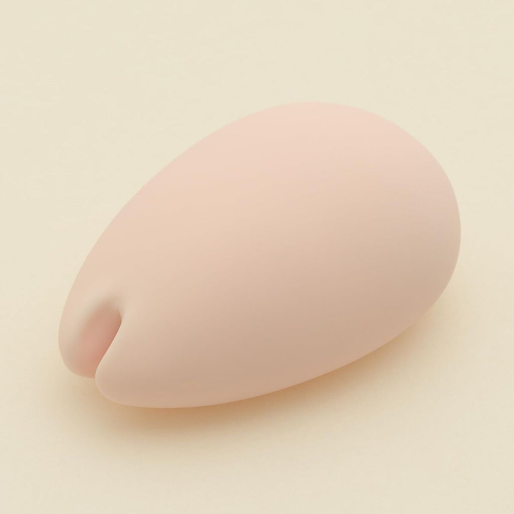 Pink silicone intimate massagerform on a beige background