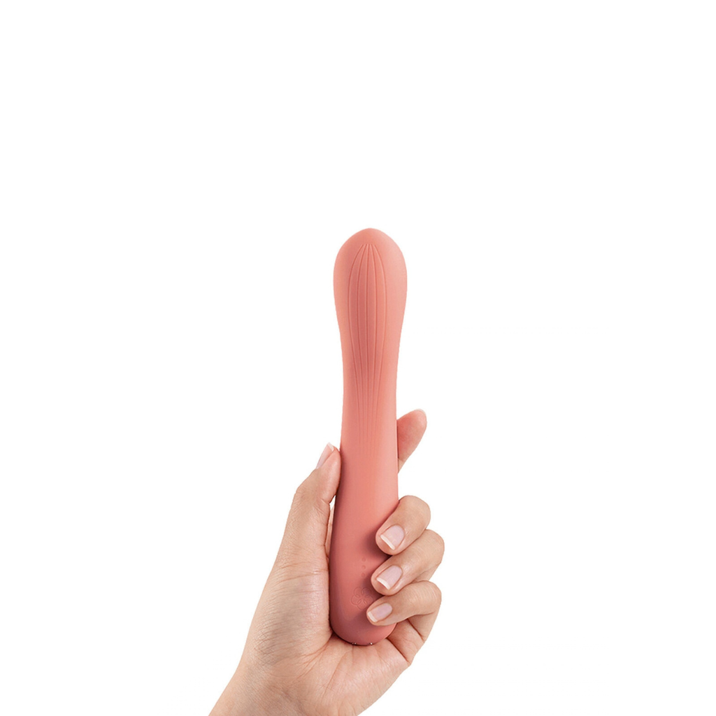Hand holding a pink silicone wand massager against a white background
