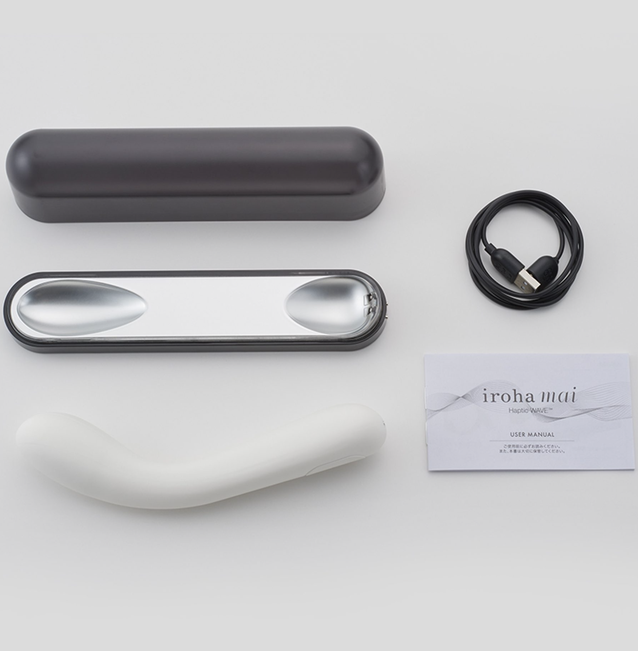 Electronic erotic device with black case, white component, and USB cable on a light gray background.