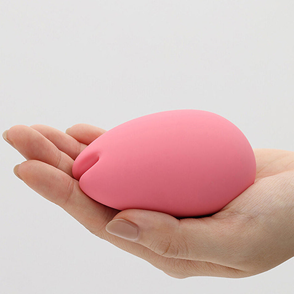 Pink stress ball held in a hand against a white background