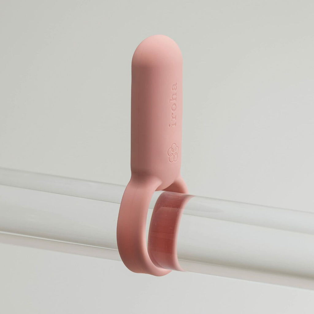 pink iroha cock ring on glass rod on a gray background