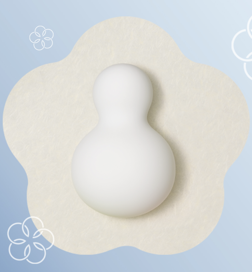 White egg-shaped object on a beige cushion with a light blue background