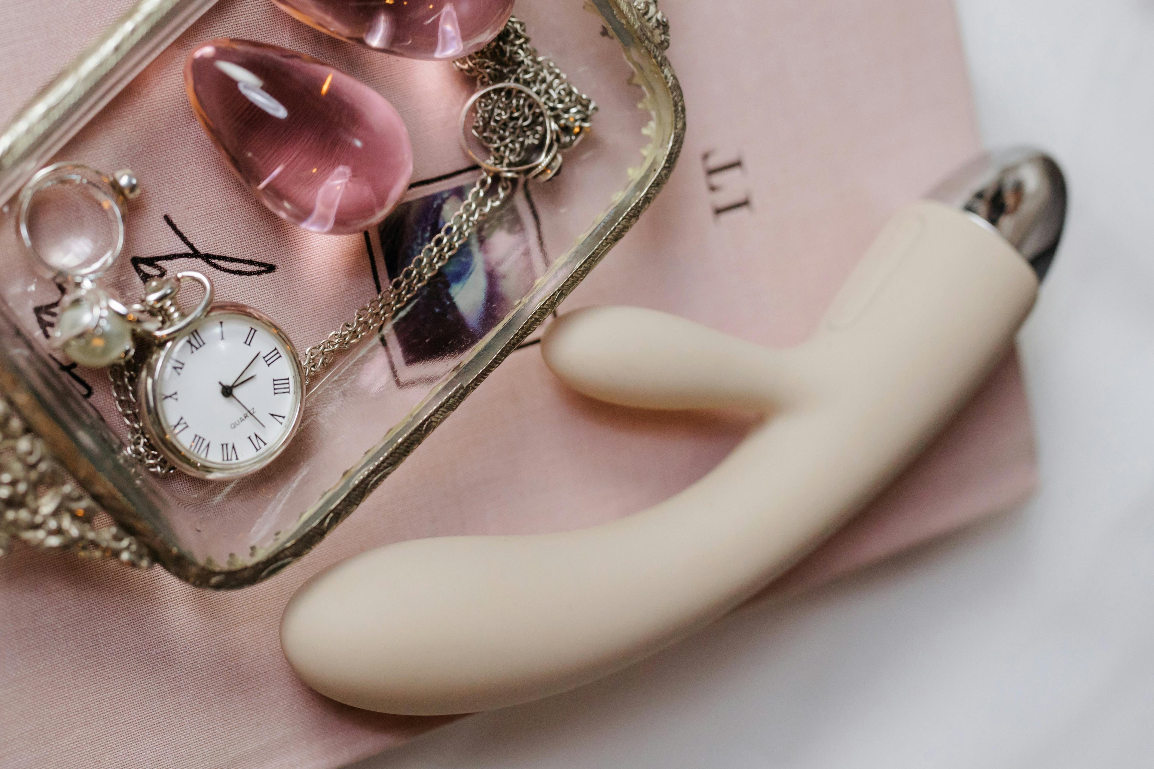 premium rabit vibrator with an assortment on luxury accessories for women on a pink background