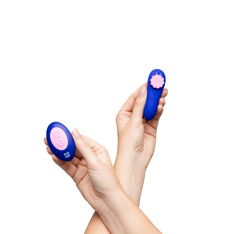 Two blue and pink vibrator devices held by a person on a white background