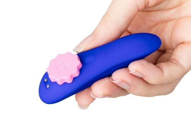 Hand holding a blue and pink adult toy on a white background