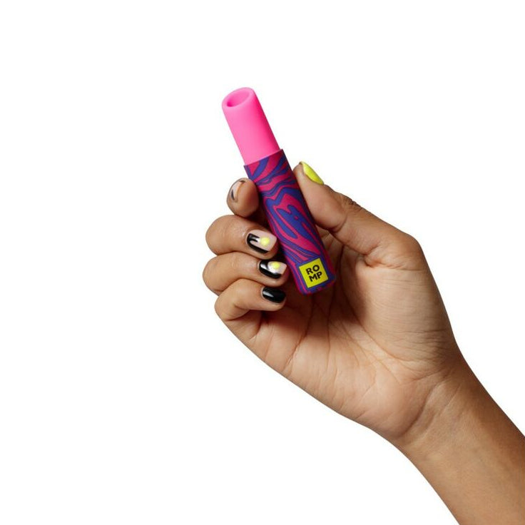 Hand holding a pink lipstick vibrator with a colorful design on a white background