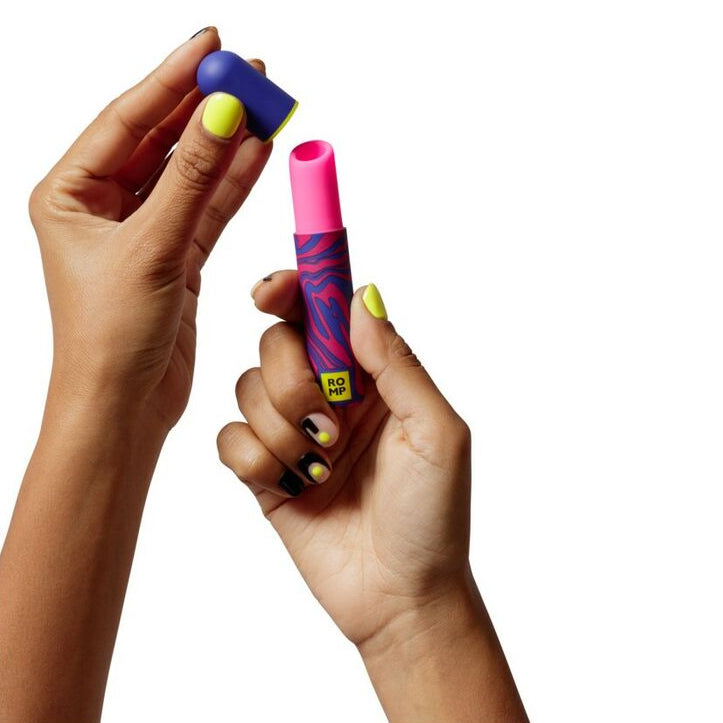 Two hands holding colorful lipstick vibrator against a white background