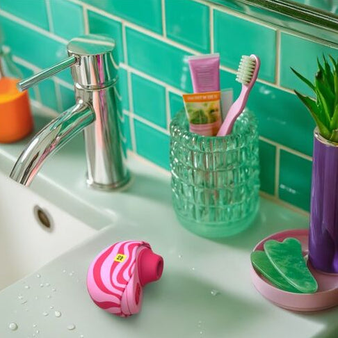Bathroom sink with various items including a soap dispenser, toothbrush holder, and soap dish.