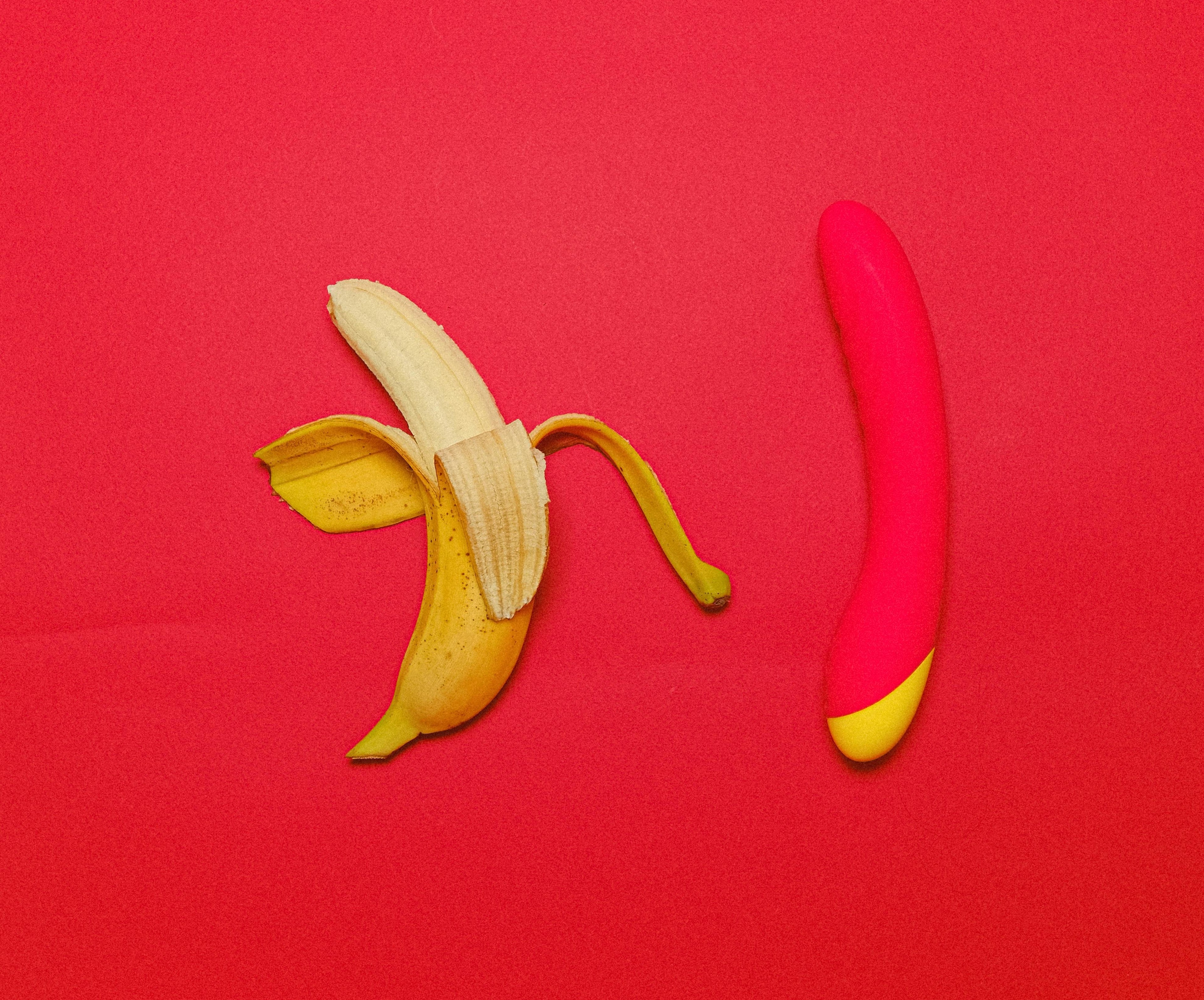 banana and red dildo over a red background