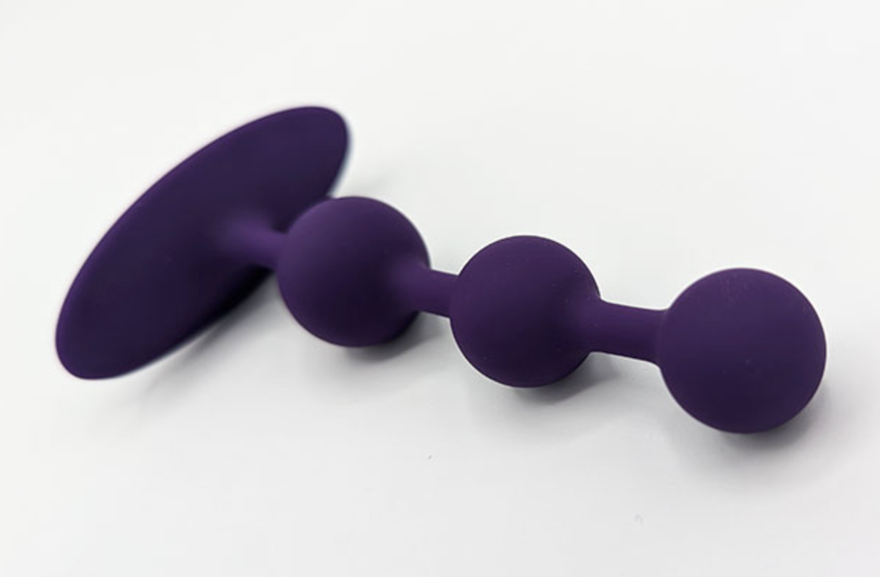 purple anal beads over a white background
