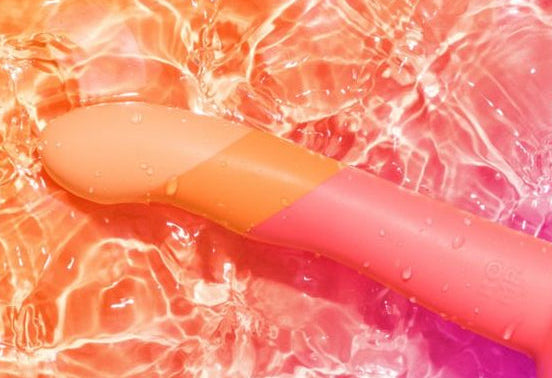 Colorful waterproof dildo on a multicolored abstract background