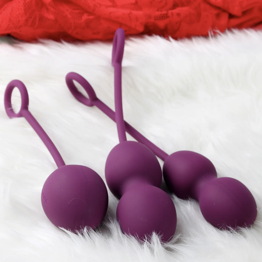 purple sexual wellness excersize balls for women on a white fur table