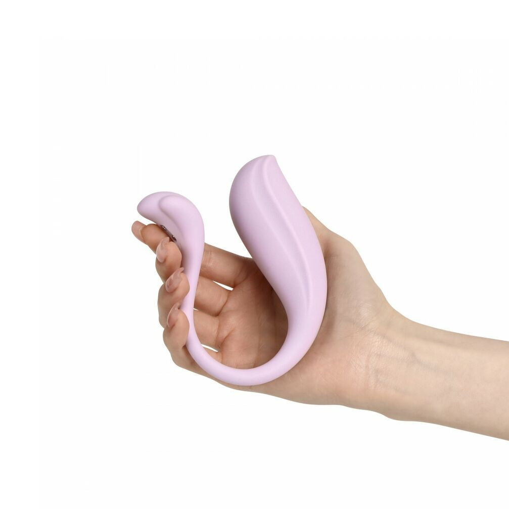Hand holding a pink silicone erotic product against a white background