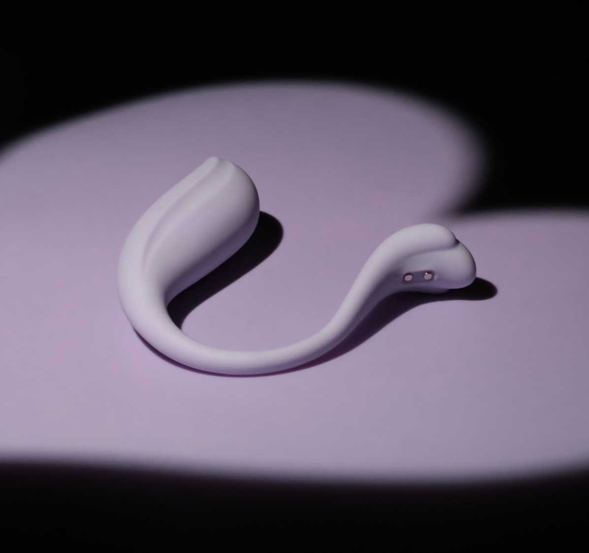 Purple silicone curved vibrator on a dark background