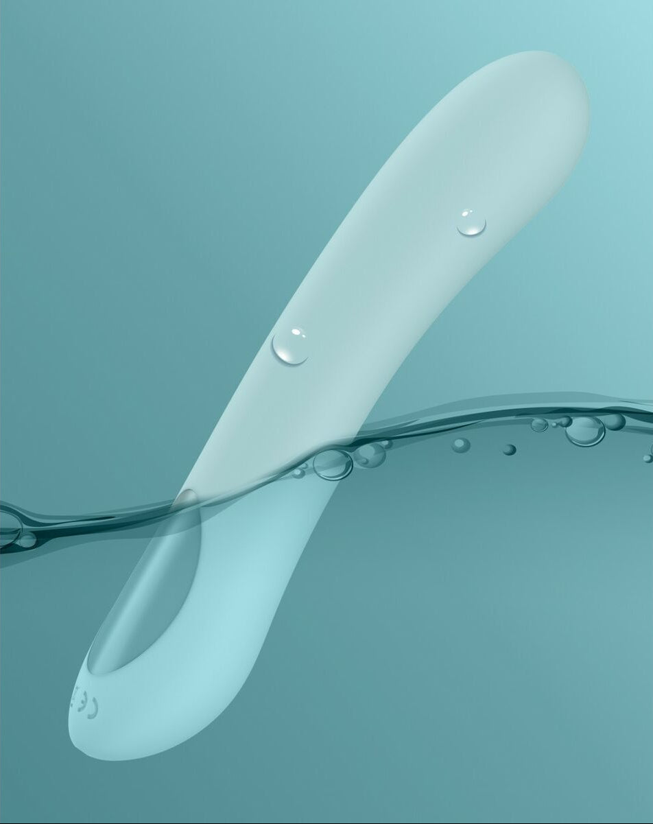 Silicone dildo with water droplets on a teal background