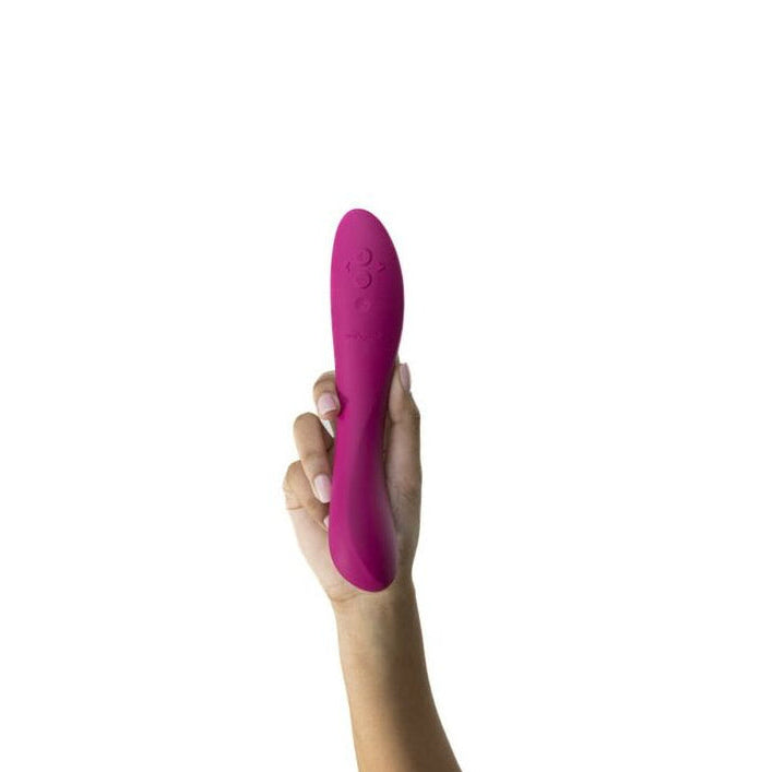 Hand holding a pink pleasure toy product against a white background
