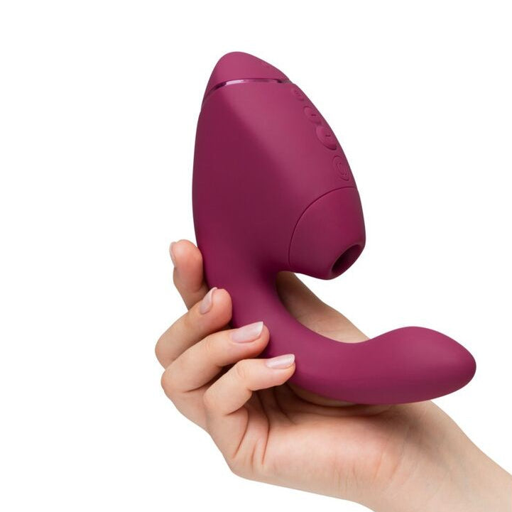 Hand holding a purple electronic device for adults only against a white background