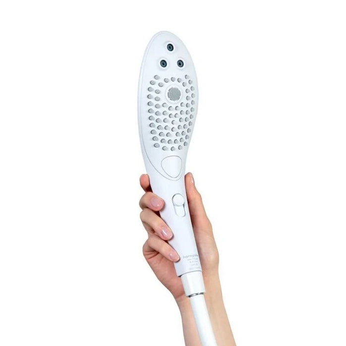Hand holding a white handheld pleasure showerhead against a white background