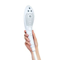Hand holding a white handheld pleasure showerhead against a white background